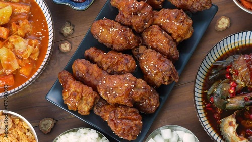 Rotation, Traditional Korean food, Korean Fried chicken with spicy sauce  with rice, seaweed and Kimchi pickle on wooden table.
