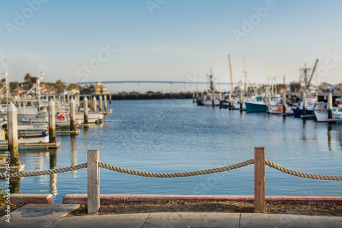 Rope railing with the blurred background of fishing boats and Coronado bridge, Tuna Harbor, San Diego bay, California