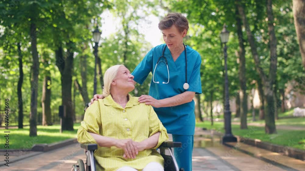 Professional nurse talking to senior woman in wheelchair, medical service Professional nurse talking to senior woman in wheelchair, medical service