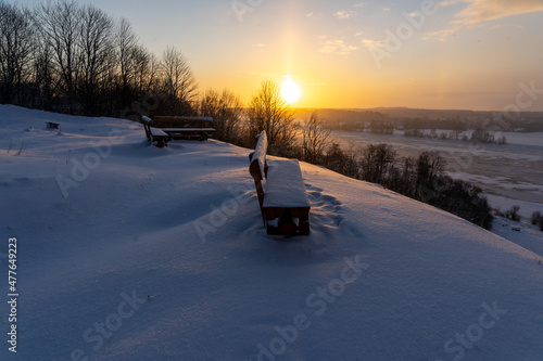 a bench at the top of the mound overlooking the river