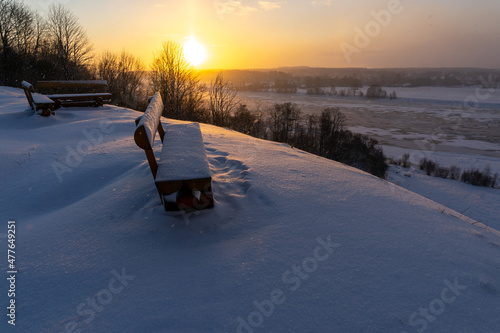 a bench at the top of the mound overlooking the river