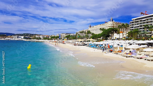 фотография Cannes, Cote d'Azur, France - October 2019: People sunbathing on a hot summer da