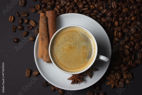 A cup of espresso coffee with cinnamon, coffee beans around. Natural coffee with additives. Invigorating drink