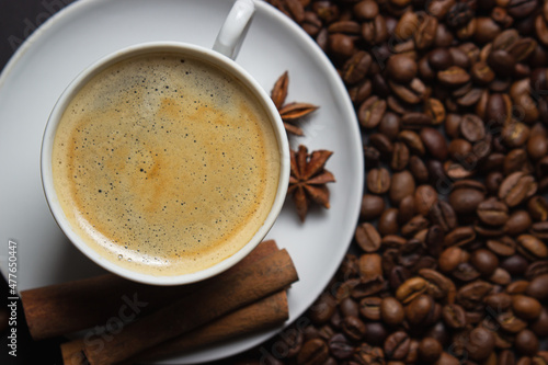 A cup of espresso coffee with cinnamon  coffee beans around. Natural coffee with additives. Invigorating drink