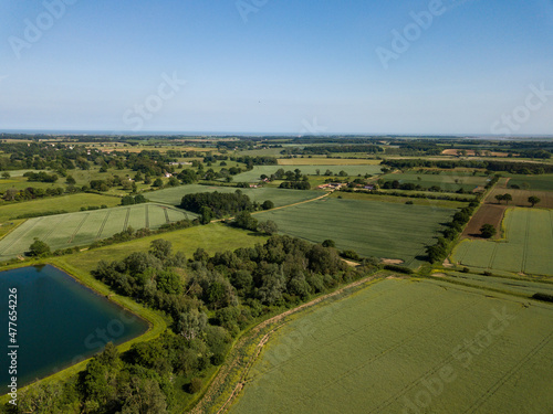Aerial view of a patchwork of farm fields in the Suffolk countryside with a large reservoir in the foreground