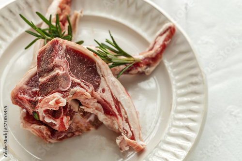 Raw lamb chops on plate photo