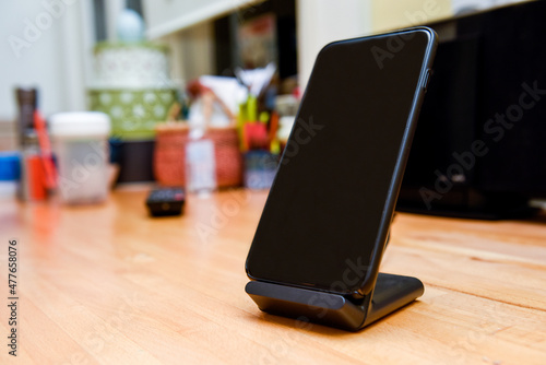 Mobile cell phone charging on wireless charger in home interior photo