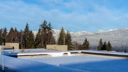 Alpine mountains viewed from snow-covered flat rooftop. © Andrew