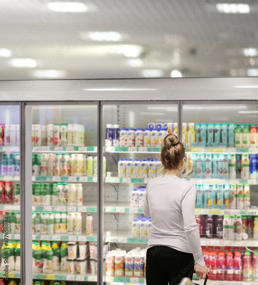 Woman choosing frozen food from a supermarket freezer.