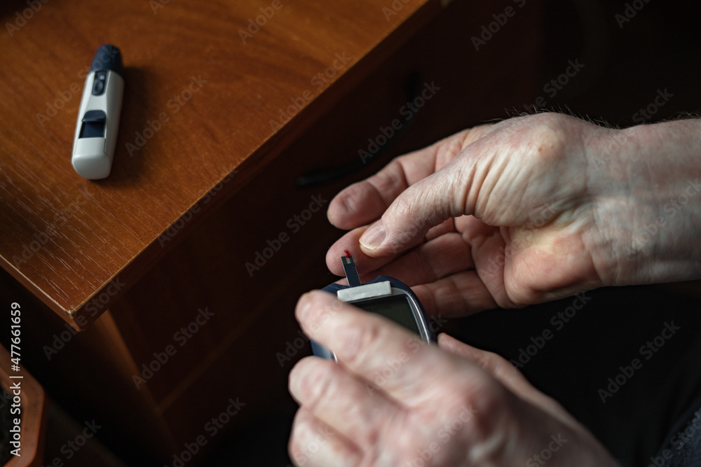 Anonymous person piercing finger to check blood sugar Anonymous person piercing finger to check blood sugar