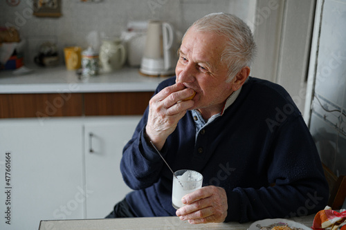 Elderly man having snack with dairy drink