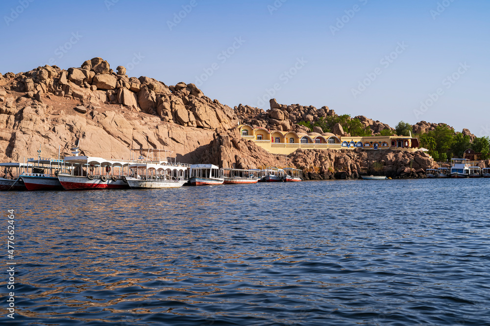 Navigating the Nile River, several empty tour boats waiting for tourists near a Nubian town. Photograph taken in Aswan, Egypt.
