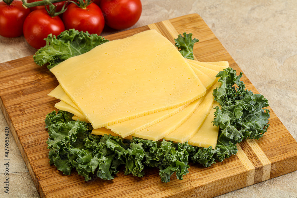 Sliced Gauda cheese over board Sliced Gauda cheese over board