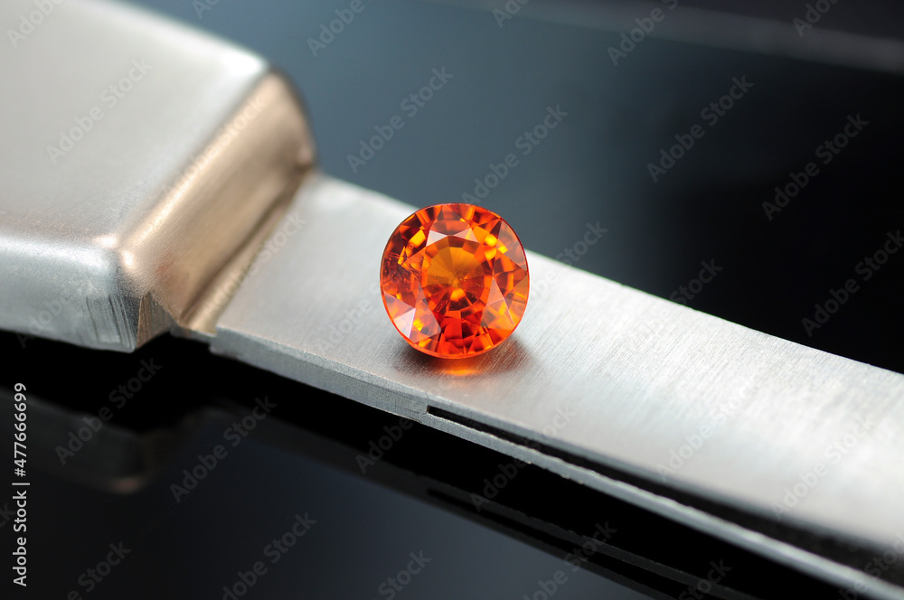 Rich mandarin orange color natural spessartine garnet loose gemstone. Small  inclusions, unheated, untreated, cushion faceted stone setting placed on  tweezrs. Gray gradient background. Gemolody theme. Stock Photo | Adobe Stock