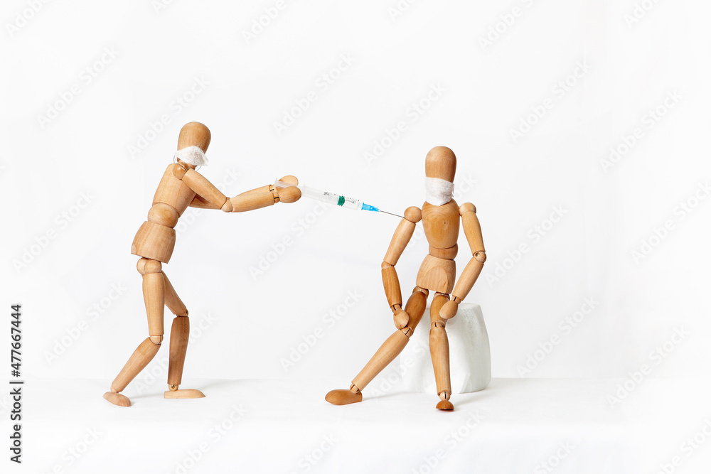 Wooden mannequins, on a white background. Vaccination. Wooden mannequins, on a white background. Vaccination.