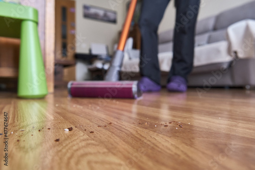 A unrecognizable woman out of focus vacuuming. Focus on the dirt