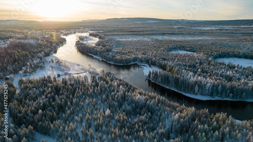 Bild auf Leinwand Aerial view of snowy winter forest with black river
