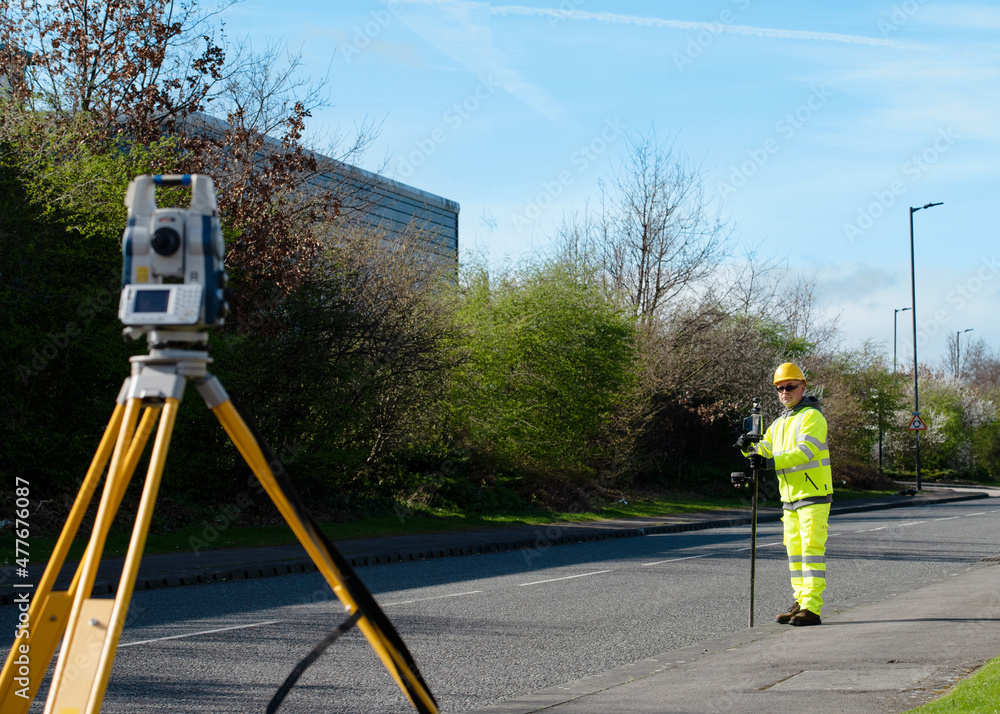 Surveyor doing road survey using modern robotic total station EDM ...