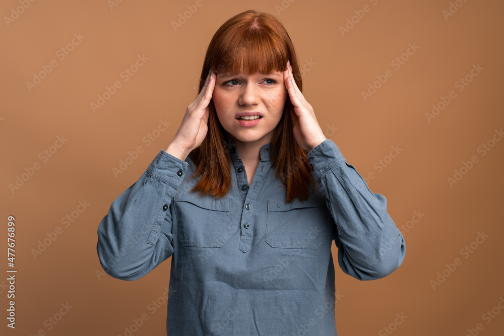 Close up isolated portrait of young stressed angry woman holding hands on head Close up isolated portrait of young stressed angry woman holding hands on head