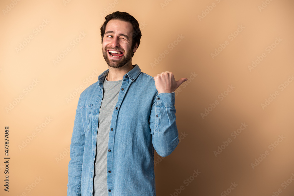 Funny man pointing at copy space and looking with amazement, showing empty place Funny man pointing at copy space and looking with amazement, showing empty place