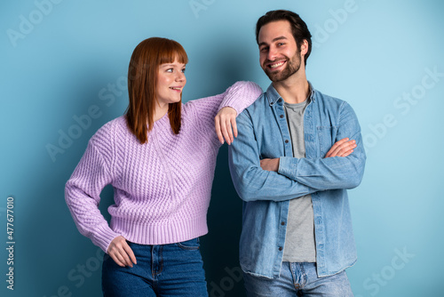 Young pretty couple isolated on blue background. Youth, hipster style, students, friends together