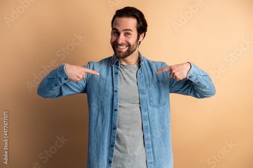 Tela Bossy man in denim shirt pointing at himself and looking with wide smile, demons