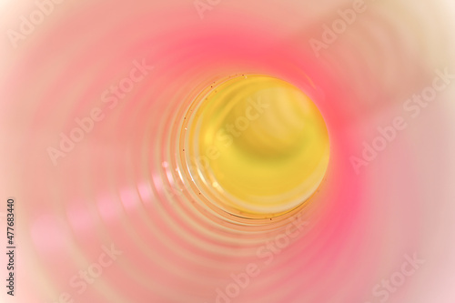 Pink and yellow slinky walking spring toy detail, pastel plastic spiral abstract background	 photo