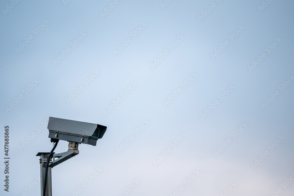 Digital CCTV camera on a metal pole, blue pastel background. Copy space. Digital CCTV camera on a metal pole, blue pastel background. Copy space.
