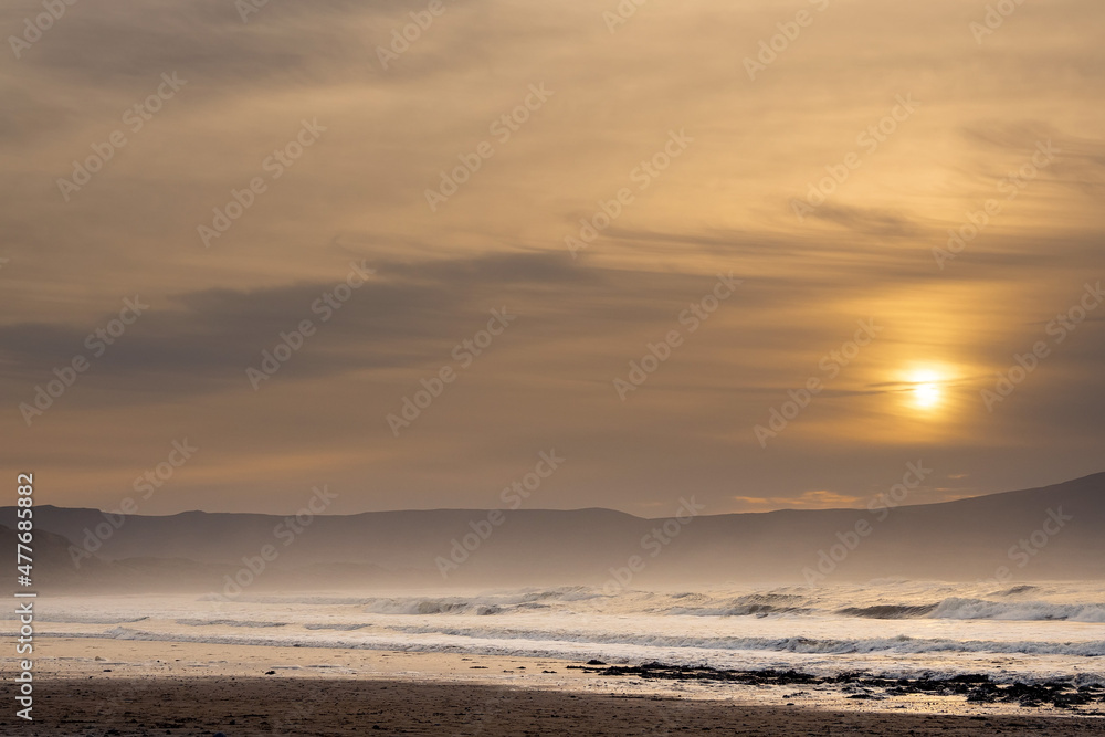 Strandhill beach at sunset. Sligo, Ireland. Big beach with stunning view and powerful ocean waves. Popular for surfing. Calm tranquil atmosphere.
