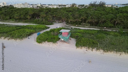 Orbiting aerial of pink lifeguard tower at sandy beach park, Surfside photo