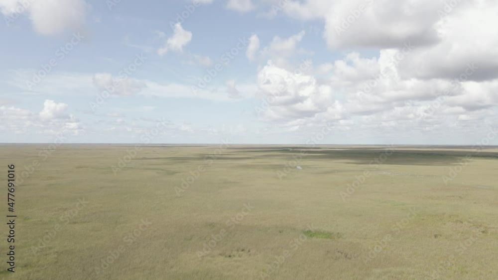 Panoramic pan of everglades savanna to low highway cutting through Panoramic pan of everglades savanna to low highway cutting through