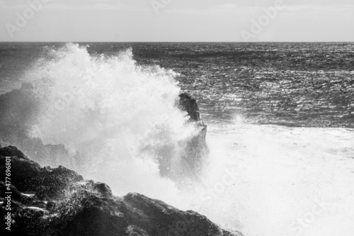 wave breaking on the rocks  black and white