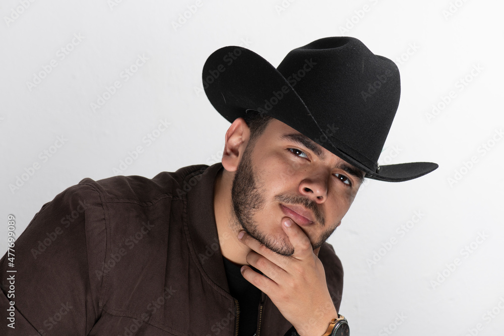 Joven latino con sombrero y barba , piel morena claro con bigote