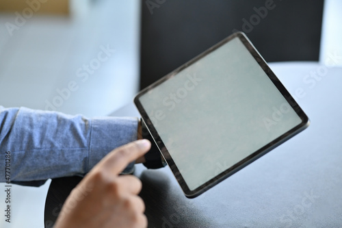 Closed up with businessman hand using digital tablet, blank screen of tablet.