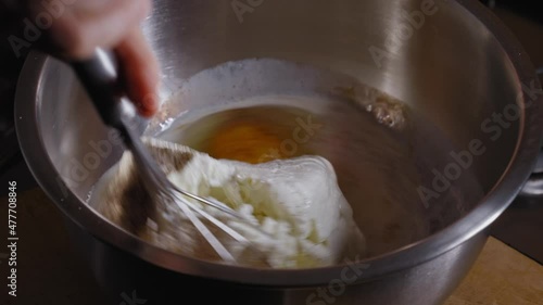 Close-up View Mixing Cream Cheese With Eggs, Milk, Salt And Pepper Using A Whisk, Making Cheese Pie - Steady Shot photo