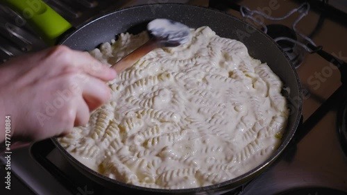 Cooking Fusilli Pasta and the Fresh Cheese Dough in a Pan Under a Lid, Cheese Pie Recipe - Steady Shot photo