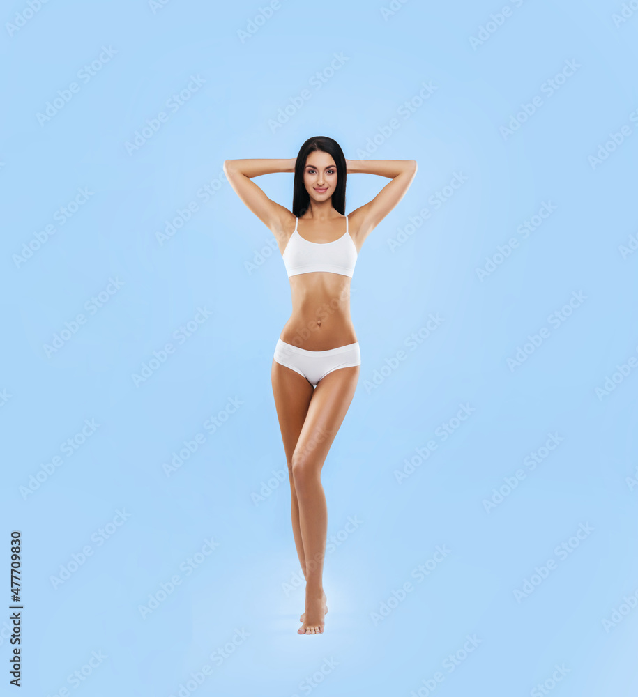 Young, fit and beautiful brunette woman in white swimsuit posing in studio. Concept of fitness, dieting and skin care. Young, fit and beautiful brunette woman in white swimsuit posing in studio. Concept of fitness, dieting and skin care.