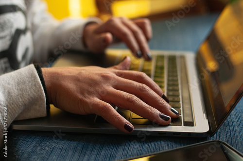 Close up de manos de mujer trabajando en laptop desde casa