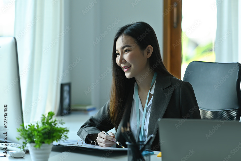 Photo of a young businesswoman checking business growth graphs at the modern working desk. Photo of a young businesswoman checking business growth graphs at the modern working desk.