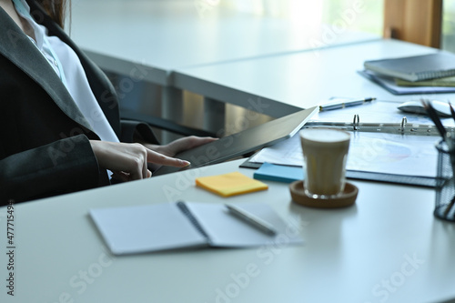 Cropped image of a female reception using a digital tablet at the modern reception counter.