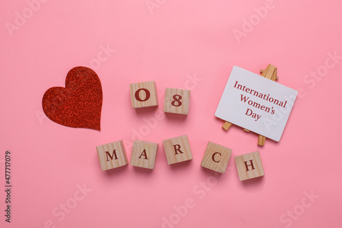 Creative Flat lay out of international women's day with sparkling red heart and 8 march on wooden cubes on pink background