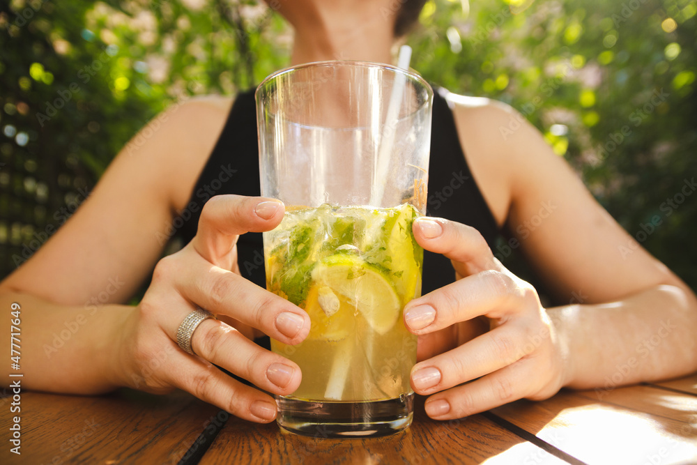 Fototapeta premium Young girl drinking summer cocktail in a outdoor pub.