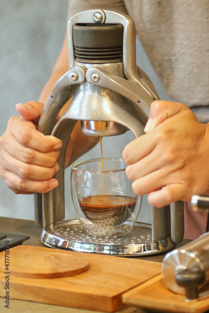 A Barista making a cup of espresso using classic espresso machine, ROK presso