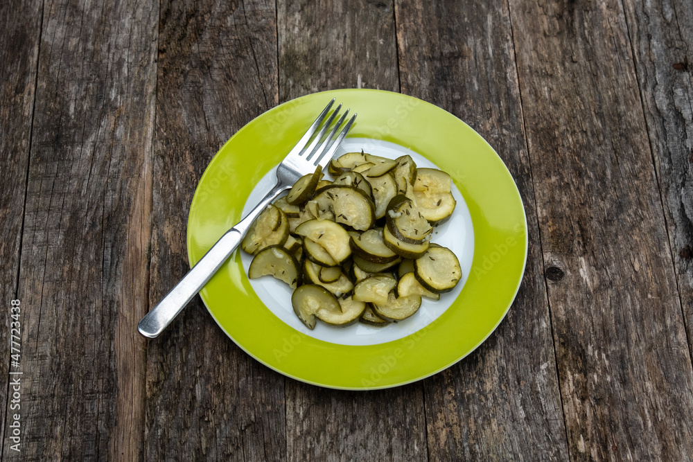 Zucchini Salat auf einem grünen Teller mit einer Gabel Zucchini Salat auf einem grünen Teller mit einer Gabel