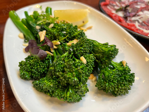 A plate of cooked green broccoli with sea salt, shot from above