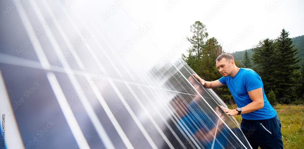 Farmer male engineer checks solar panel for integrity, providing country villa in mountains with electricity Farmer male engineer checks solar panel for integrity, providing country villa in mountains with electricity