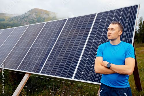 Young male farmer engineer background solar panels in background with sun light