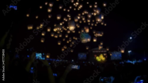 Defocused shot of tourist people foreigner traveling for launching many asian fire lanterns during buddhist festival in chinese new year. Rice paper hot air balloons in sky lantern photo