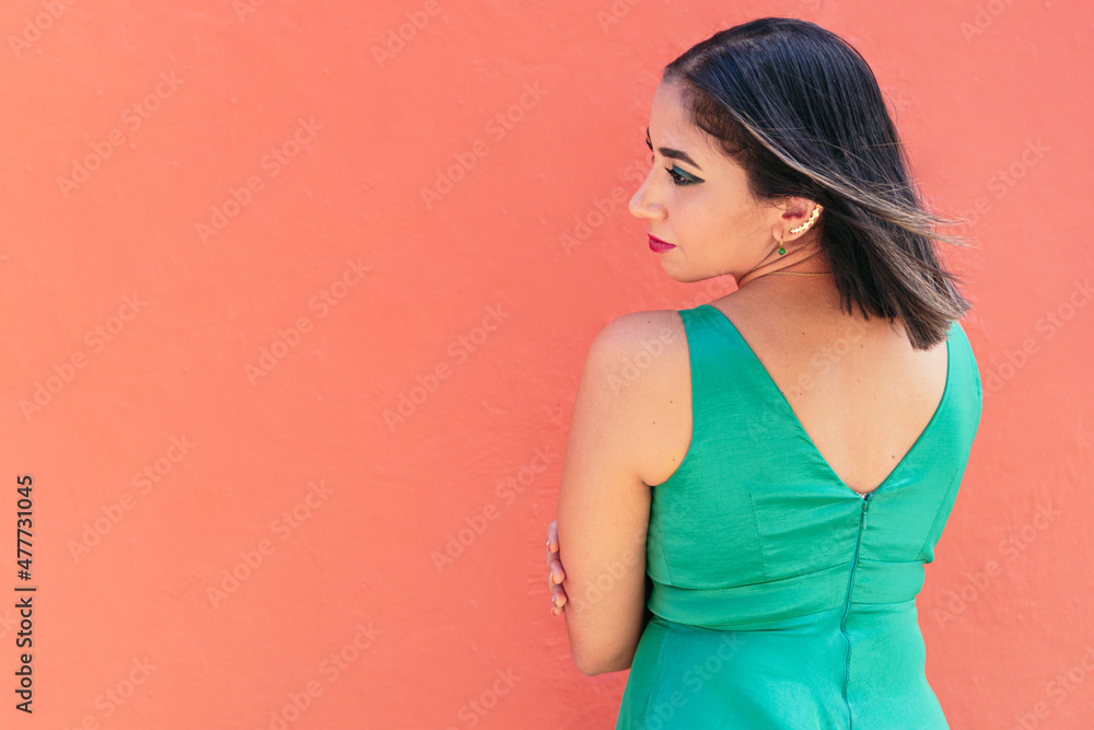 Backed woman wearing a green dress in the street Backed woman wearing a green dress in the street