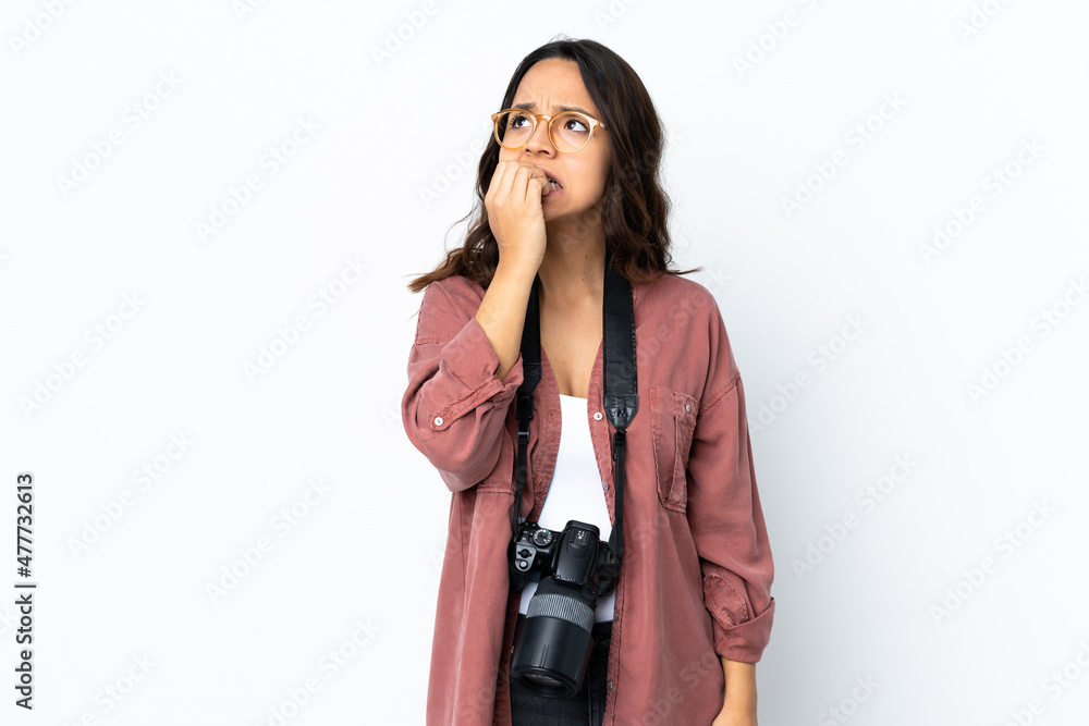 Young photographer woman over isolated white background is a little bit nervous Young photographer woman over isolated white background is a little bit nervous